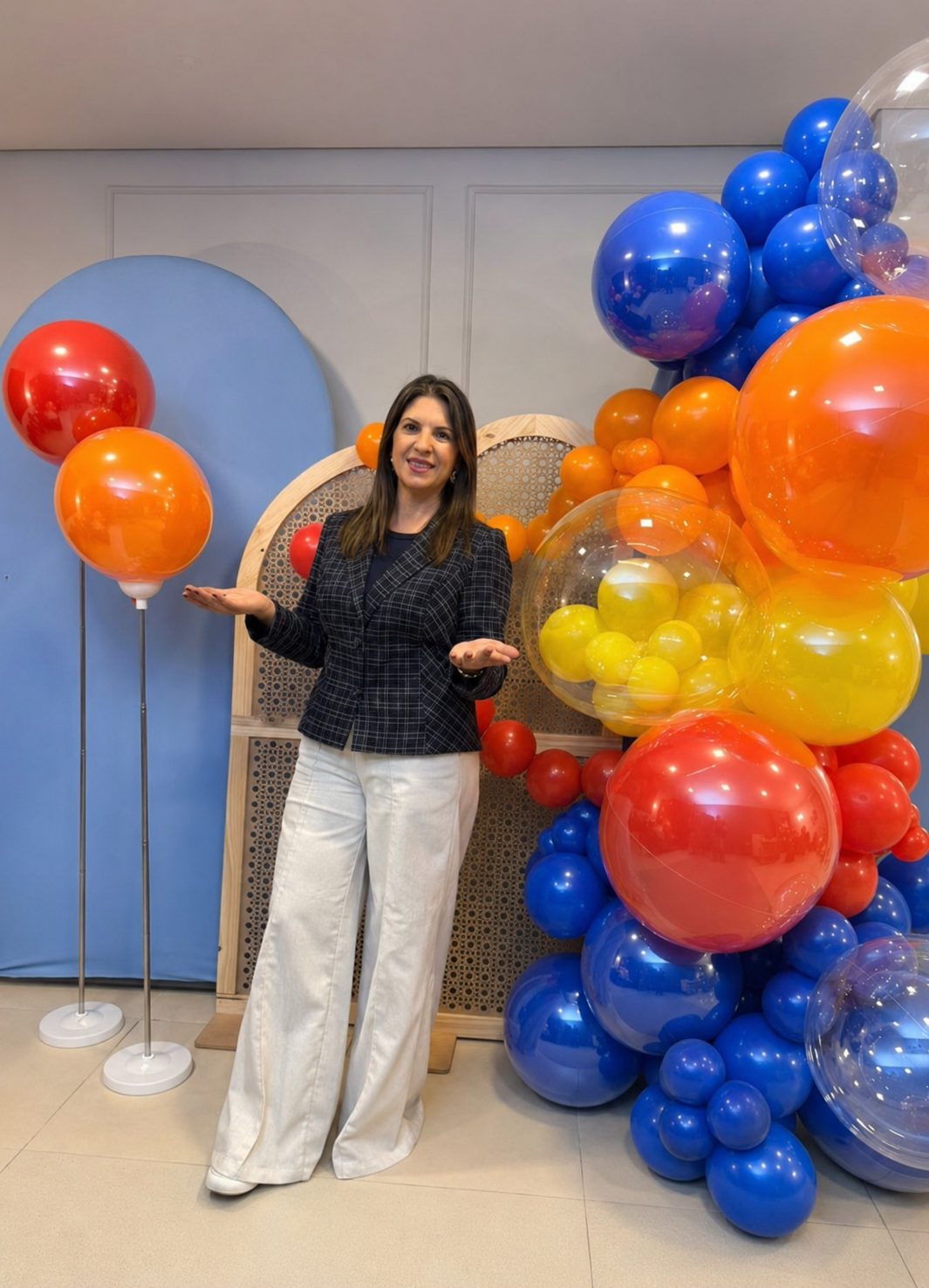 Ana Luiza ao lado de uma guirlanda orgânica de balões montada em evento real